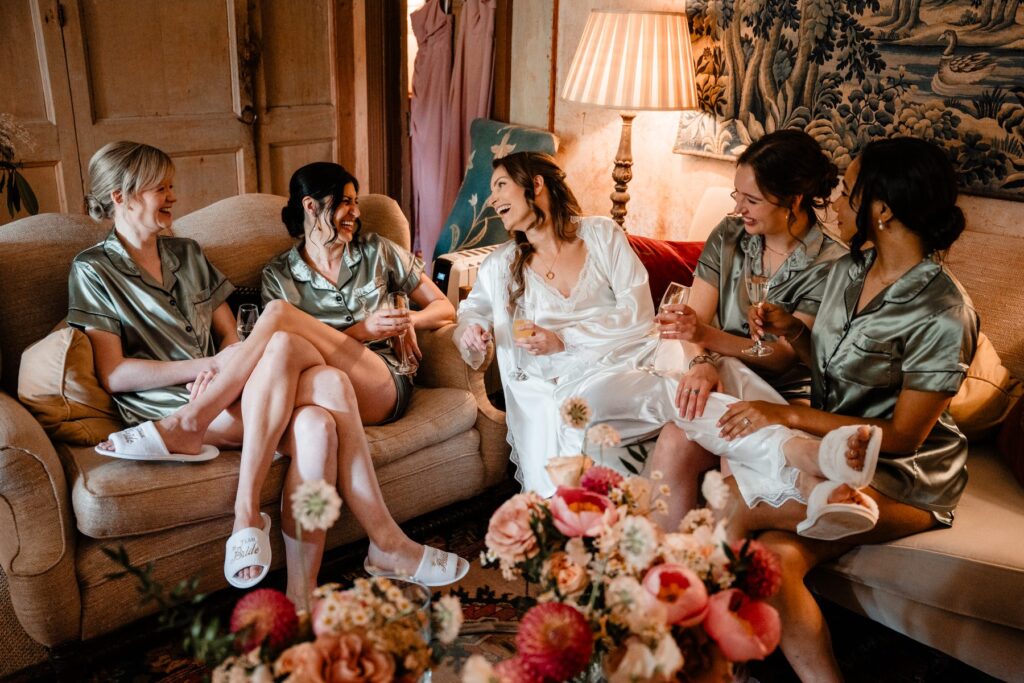 Bride and bridesmaids relax together during wedding preparations at Neidpath Castle